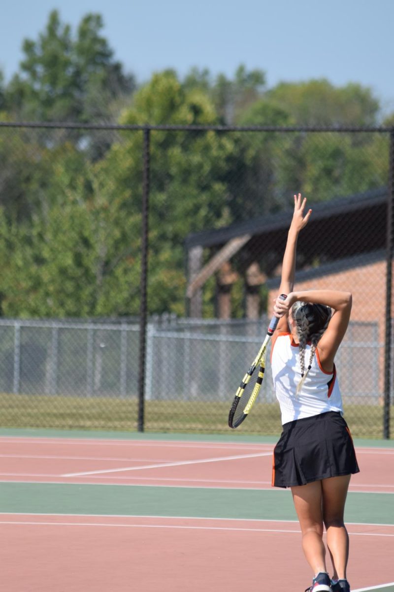 Bryndle Burks serves to her opponent during a home match.