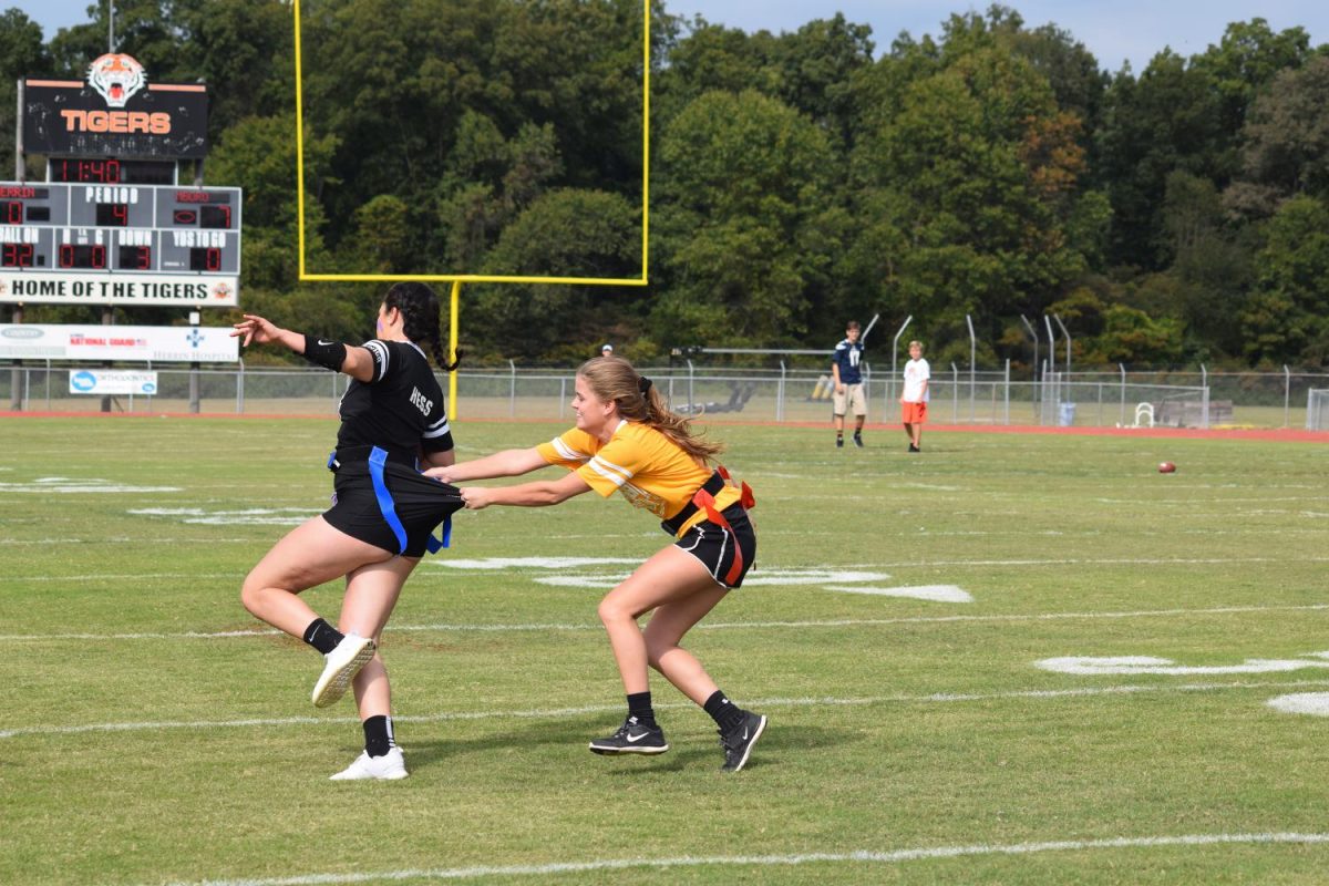 Cheyenne Hess (12) runs the ball while avoiding the grasps of Ashley Owens (11) during the powder puff game. 