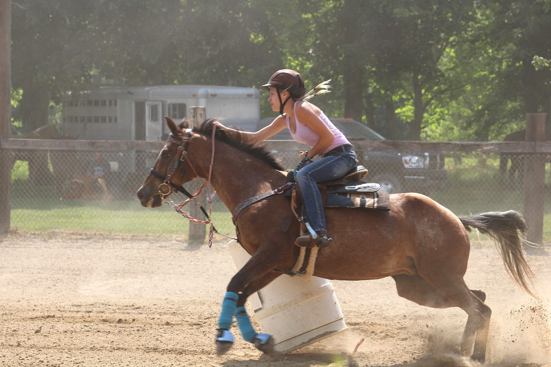 Bryndle Burks (11) pushes her horse to run home after turning the third barrel.
