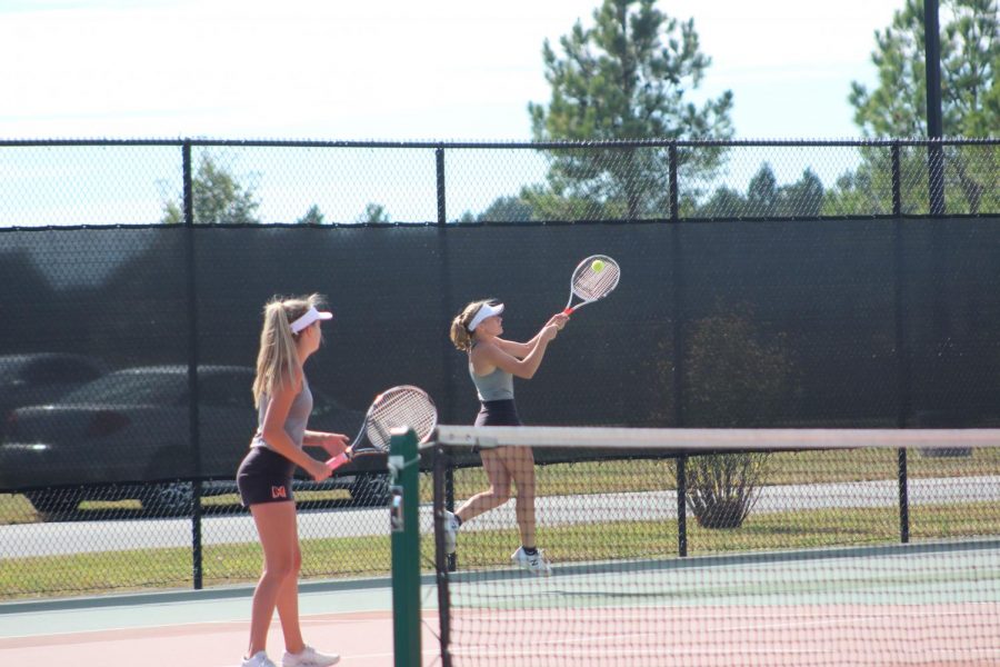 Breanna+Nesler+%2811%29+watches+as+her+doubles+partner%2C+Kelby+Weber+%2811%29+follows+through+for+a+backhand+at+Sectionals+on+October+18+at+Herrin.