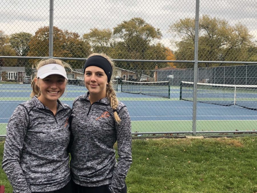 Kelby Weber (11) and Breanna Nesler (11) pose for a picture in front of the courts that they competed at State on.