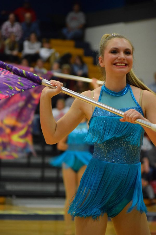 Kylie Watkins (11) smiles at the crowd after catching a partner toss at the Marion Regional Contest.