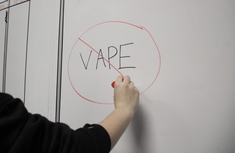 A student draws on the board to promote staying away from nicotine.