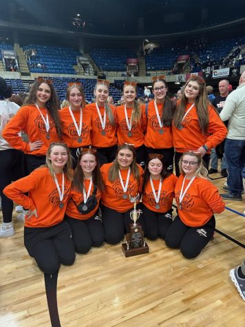 The dance team poses for picture with their new trophy.