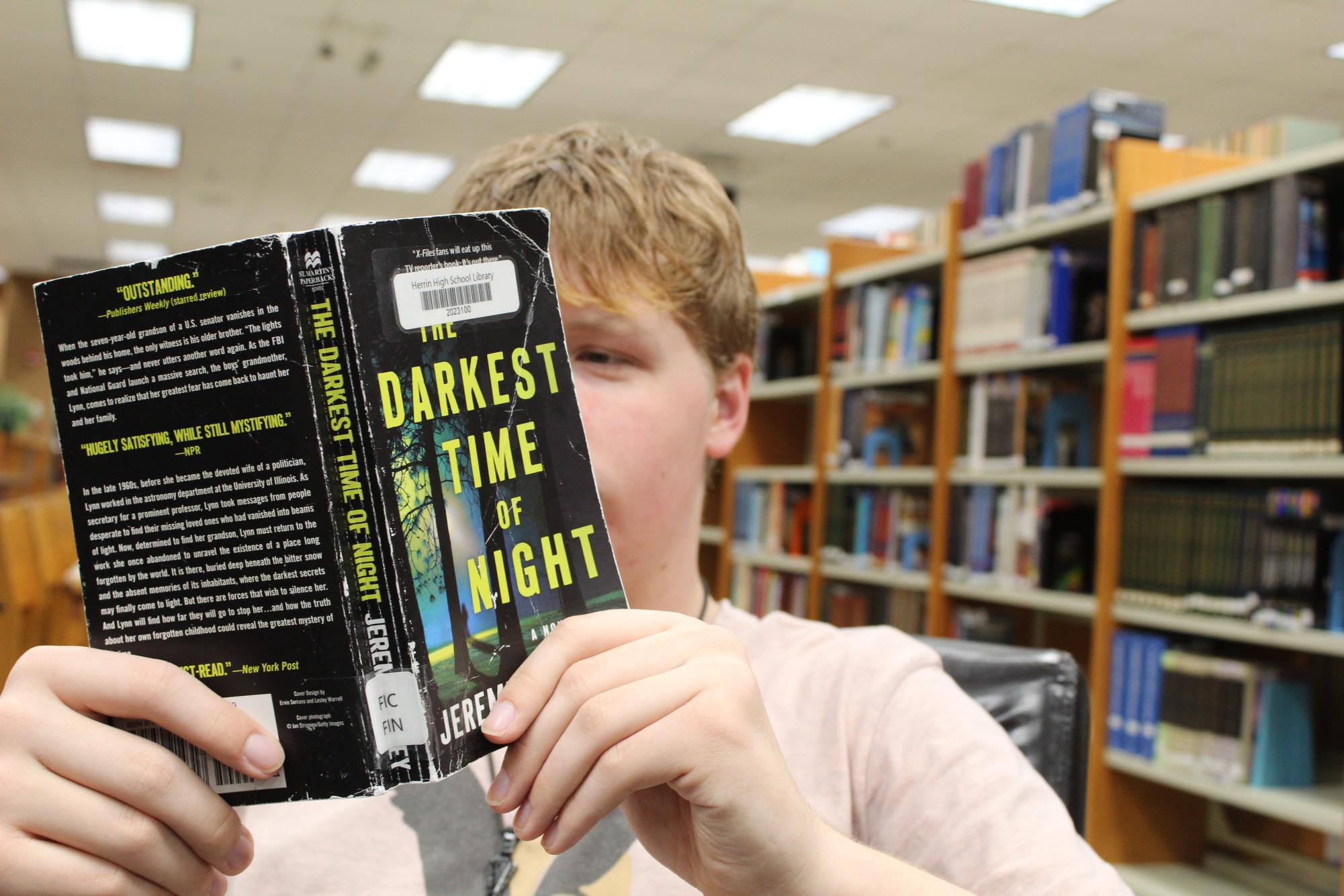 Caden Green (11) digs his nose into one of the books of the month.