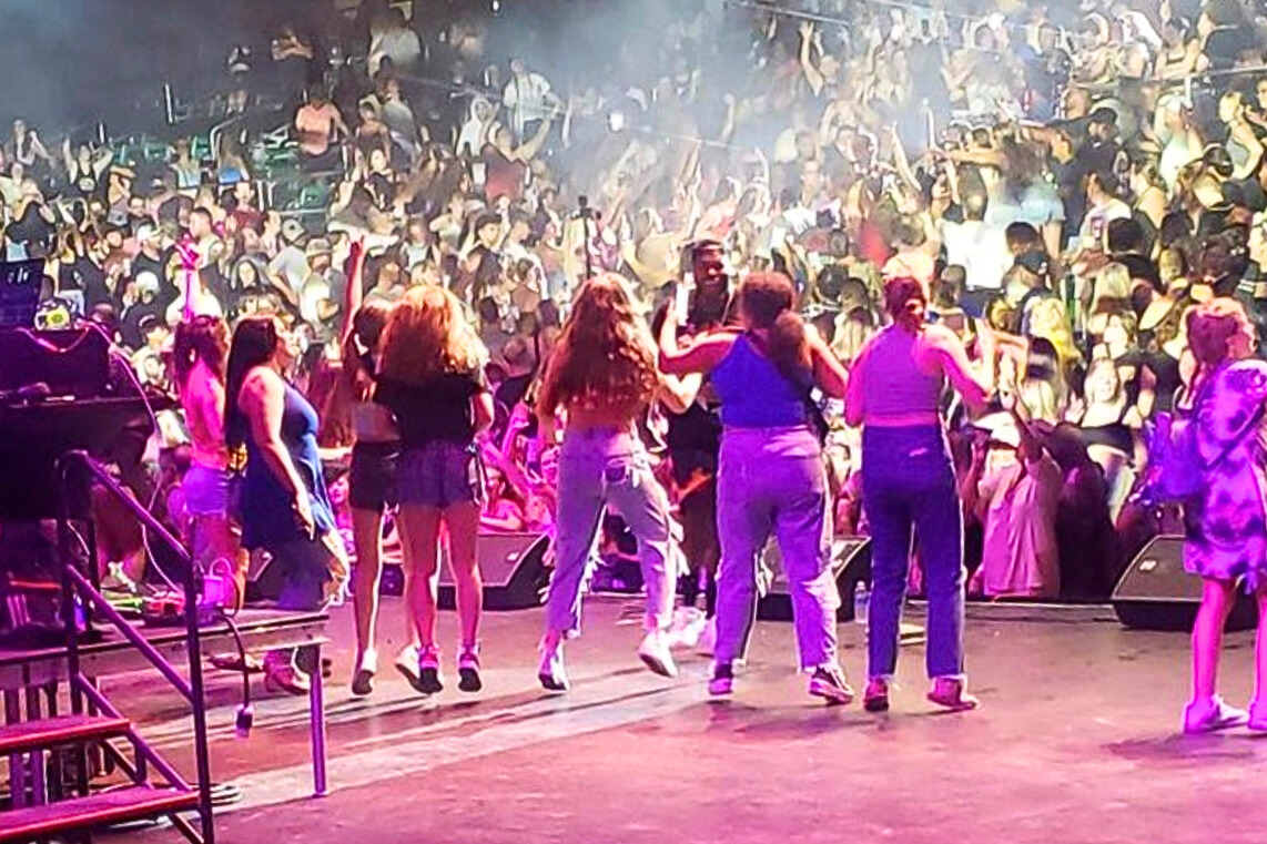 Concertgoers dance on the stage with Flo Rida.