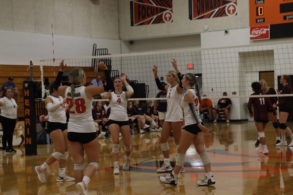 The volleyball team celebrates after scoring a point.