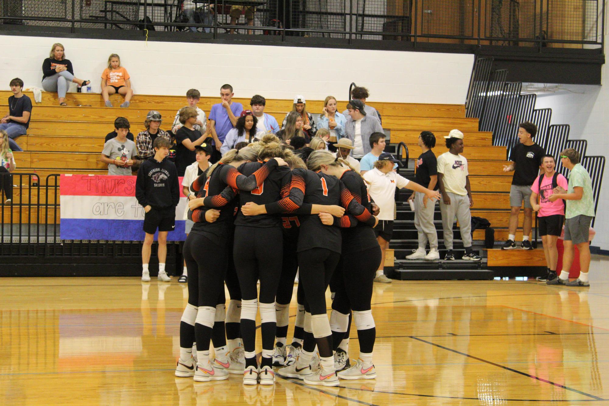 The volleyball teams huddles during their match against Johnston City.