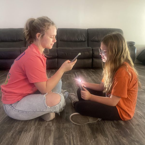 Mads LaBotte (12) and her younger sister entertain themselves with their devices of choice.
