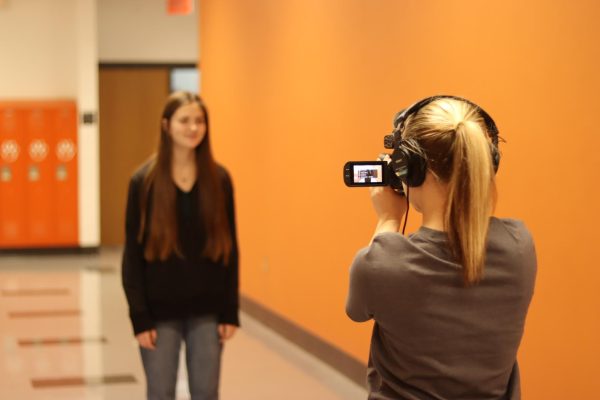 A J2 student caught interviewing a peer for her broadcast piece.