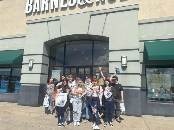 Club members pose for a picture outside Barnes and Noble, showing off their books and coffee.