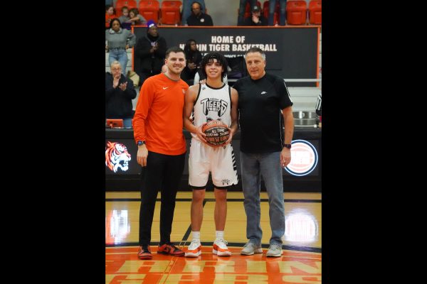 Kyrese is met at half court by his grandfather and Herrin Hall of Fame member, Irv Lukens and his uncle and Herrin High School assistant basketball coach, Justin Lukens where they are presenting him a basketball in honor of his new achievement. 
