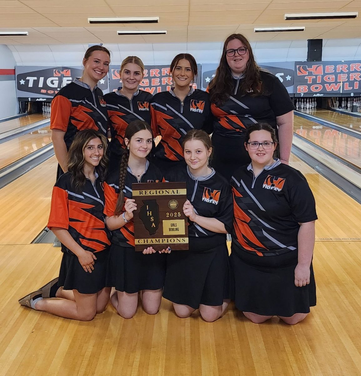  The girls bowling team poses with their new hardware, their regional championship plaque. 
