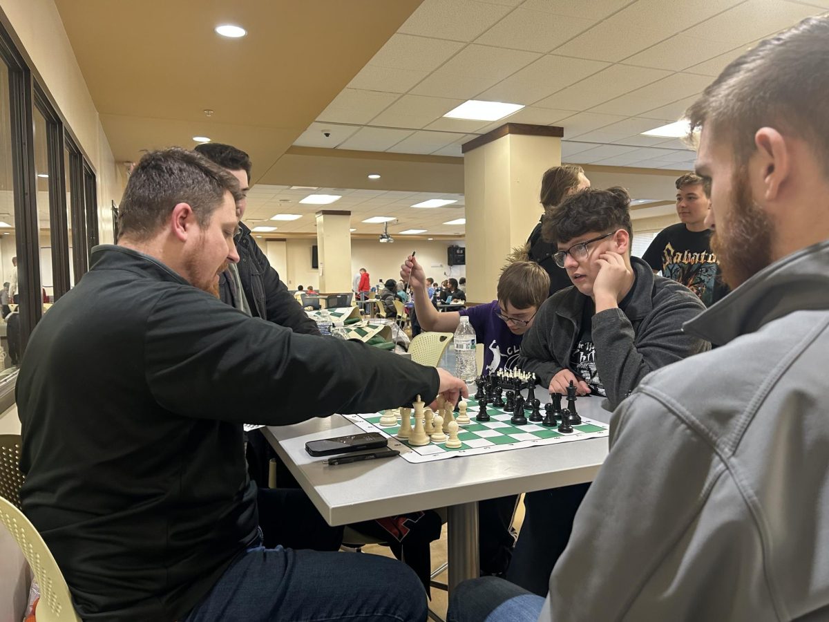 Mr. Evilsizer and CJ Robledo (10) study Robledo’s past game at the Feb. 22 chess tournament.