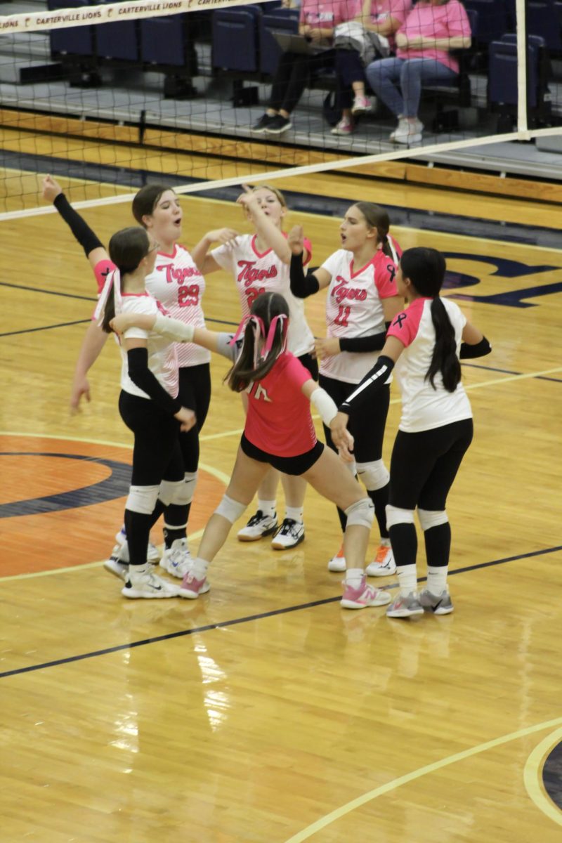 The volleyball team is excited after scoring points 
