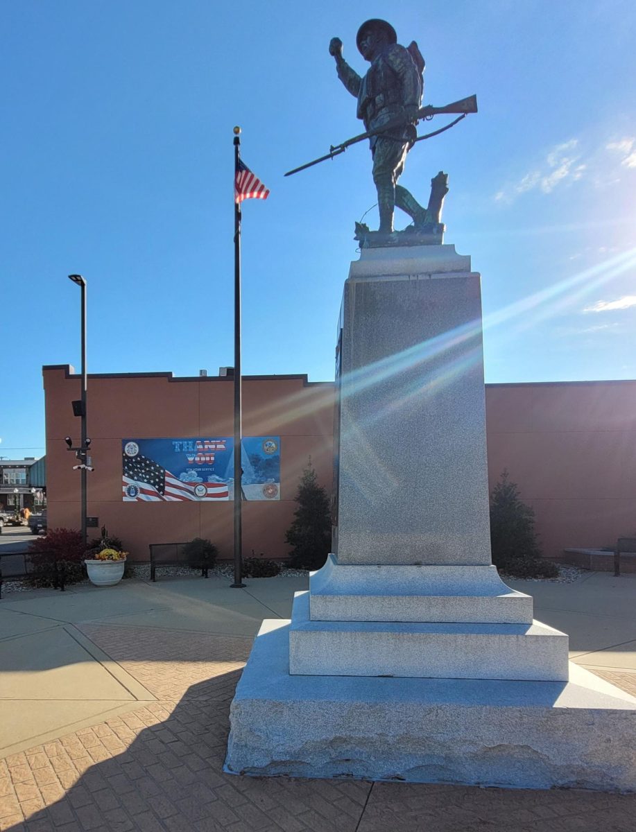 Herrin's Doughboy Statue, which was built to commemorate the veterans of Herrin. Behind it stands a veteran's mural.