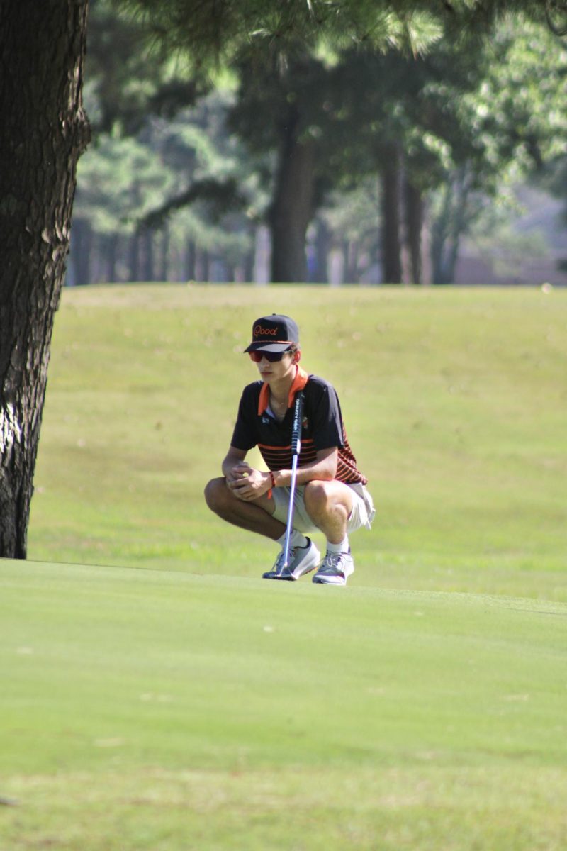 Junior Carver Hall is reading the green to find the perfect line. 