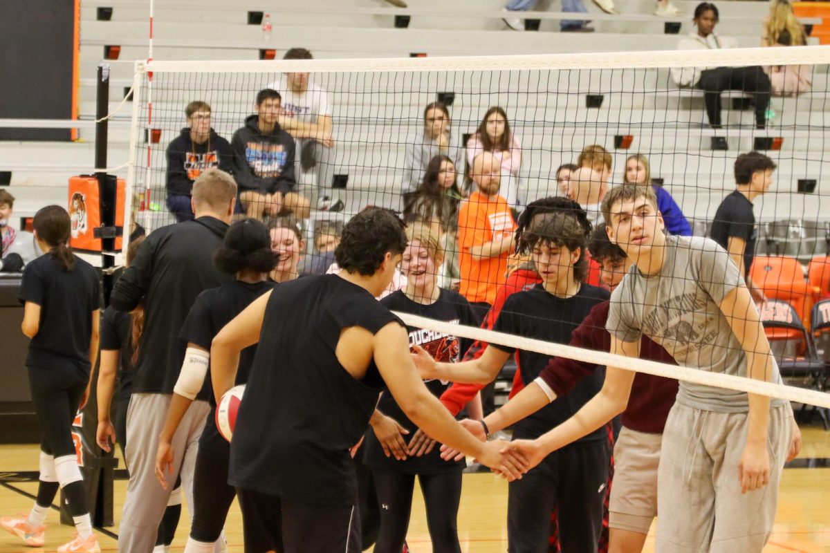 Two of the volleyball teams congratulate each other before the tournament.