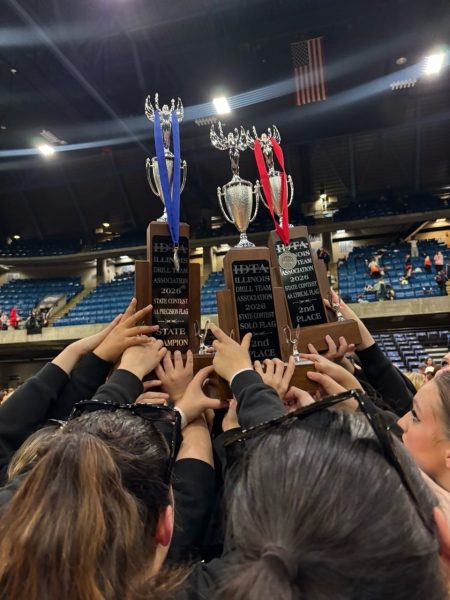 The flag team holds their trophies and medals they won