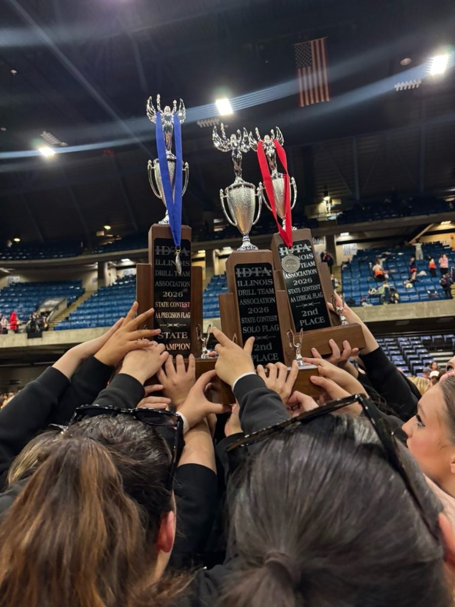 The flag team holds their trophies and medals they won
